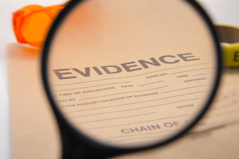Magnifying glass in front of a document with text, "Evidence"
