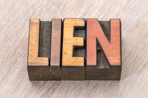 Wooden background behind a stamp with text, "Lien"