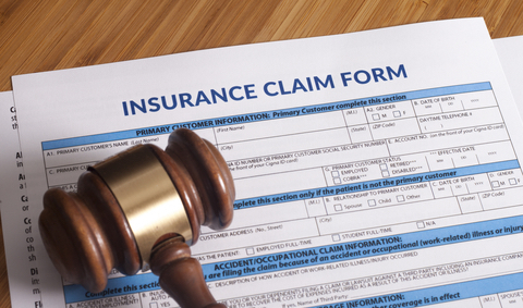 Insurance claim form beneath a court gavel
